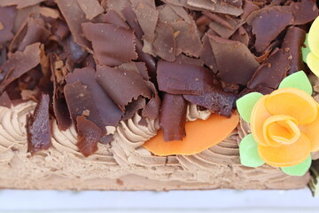 Close-up of chocolate mousse cake with dark chocolate shavings and fondant flowers