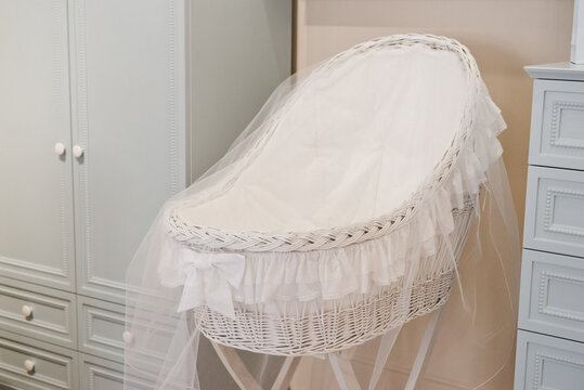 White traditional old fashioned wicker baby crib cot . Vintage baby wicker. Nice Wicker cradle for a newborn. Baby room