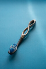modern aluminum toothbrush on a light blue surface
