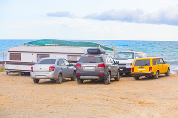 Fototapeta na wymiar Cars and camper on the seaside