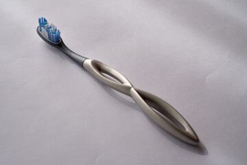 modern aluminum toothbrush on a light blue surface