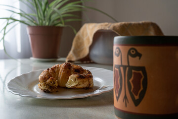 delicious Croissant and a coffee on a light table and some background elements