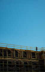 Fototapeta premium Ongoing construction of residential building with one worker on the rooftop