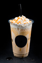 Vanilla milkshake covered with whipped cream in plastic glass