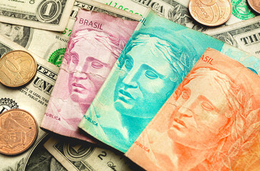 Dinheiro, Real e Dólar americano. Cédulas do Real Brasileiro sobre Dólares dos Estados Unidos. Conceito de mercado de câmbio e investimentos internacionais.