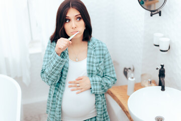 Pregnant Woman Brushing Her Teeth in the Bathroom 