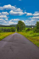 Fototapeta na wymiar Cloudy skies over a lonely country road somewhere in the Catskills region in upstate, New York