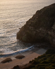 A big cliff in front of the sea and a green coast, during a beautiful sunset in Quirilluca beach
