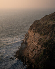 The sea in front of a big cliff on a beautiful sunset with zoom
