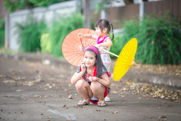 close-up background view of an asian girl Running around and carrying parasols during school...