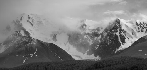 Black and white landscape. Snow-capped mountain peaks. Traveling in the mountains, climbing. 