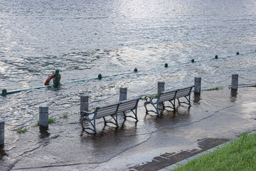 台風後の満潮で柵が見えなくなるほど水没する隅田川の遊歩道とベンチ