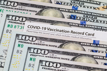 Covid-19 vaccination card and cash money. Covid vaccine lottery, bonus and incentive concept.