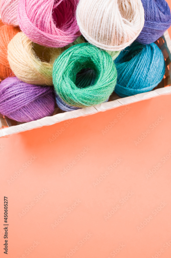 Poster vertical shot of colorful yarns on a box isolated on light background