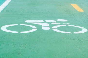 Bicycle symbol paint white color on green road for biking track safety