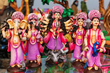Beautiful handmade statuette of a Goddess Durga idol is displayed in a shop for sale in blurred...