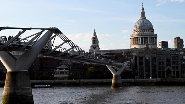 Timelapse of St Paul's Cathedral and the Millennium Bridge With People Walking Across and Boats Going Underneath on the River Thames, London, England.