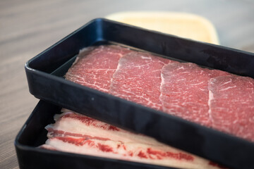 The lean pork and beef cut into thin slices is placed in a black tray