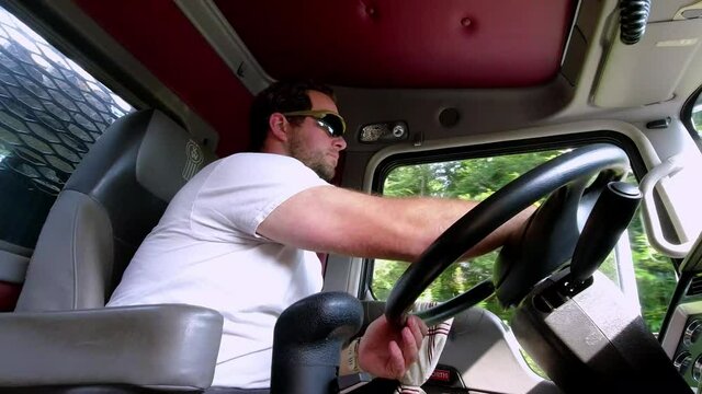 Trucker drives semi tractor trailer diesel truck, changes gears