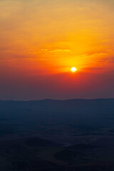 Sunrise at Makhtesh Ramon Israel. The sun is in the clouds.