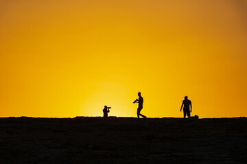 Fototapeta na wymiar Silhouettes of photographers against the background of the rising sun. Makhtesh Ramon
