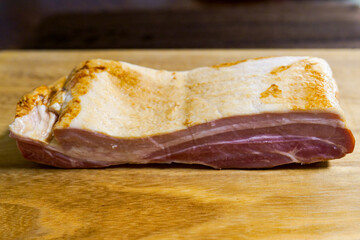 木製のまな板の上に置かれた調理前のベーコンブロック