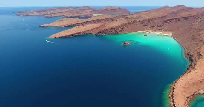Slow Forward Flight of Unique Desert Island Cliffs and Amazing Water Scenery with Speeding Powerboat in the Distance