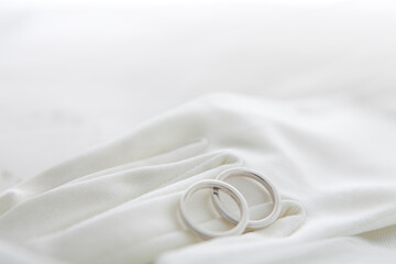 Two wedding rings on a white veil