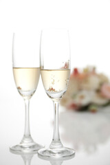 Two champagne glasses with a wedding bouquet