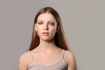 Naklejka premium Beautiful young woman with dyed eyebrows on grey background