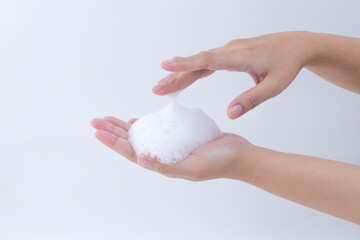 white soapy foam bubbles texture on hand. cleaning and wash essence facial cleanser skin care concept