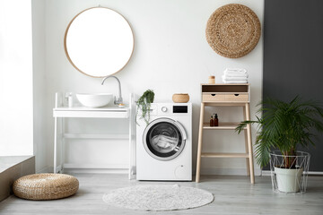 Interior of bathroom with modern washing machine