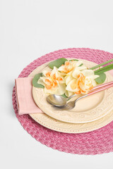 Obraz na płótnie Canvas Beautiful table setting with narcissus flowers on white background