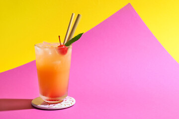 Glass of tasty summer cocktail on color background