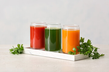 Glasses with healthy juice on light background