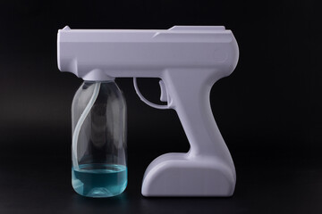 Back side of portable device for spraying isolated on a black background. White alcohol spray for disinfection. Alcohol Fog Misting Nano Sprayer Gun.