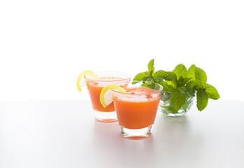Carrot juice with mint leaves, isolated on white background