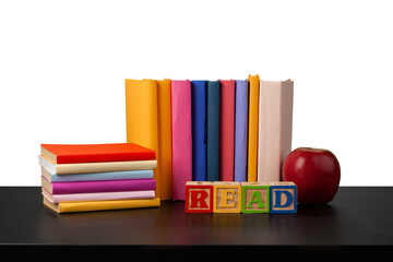 Stack of books and apple on tabletop against white background