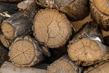 Natural wooden background - closeup of chopped firewood.   Logs cut stacked