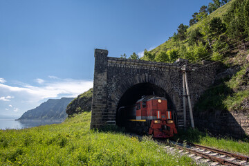 Fototapeta na wymiar The train leaves the tunnel on the Circum-Baikal Railway
