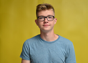 High resolution photo of caucasian teenage boy with smile on yellow background