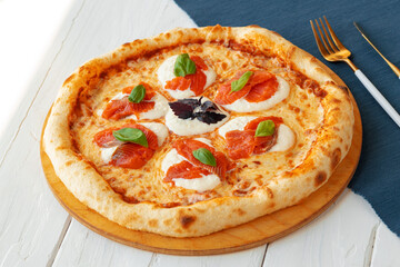 Hot pizza Margherita on white wooden table