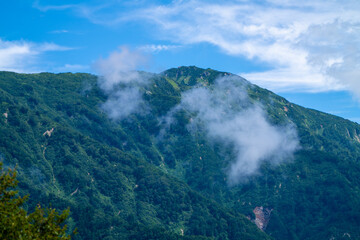 富山県中新川郡上市町の中山から立山の剱岳を望む登山をしている風景 A view of mountain climbing with a view of Tsurugidake in Tateyama from Nakayama in Kamiichi Town, Nakashinagawa County, Toyama Prefecture.