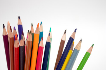 Multi-colored pencils on a white background.
