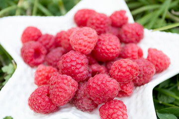 Ripe fresh raspberry in white plate