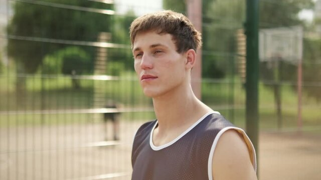 A handsome guy is coming to basketball playground outdoors