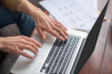 Male hands over laptop keyboard writing