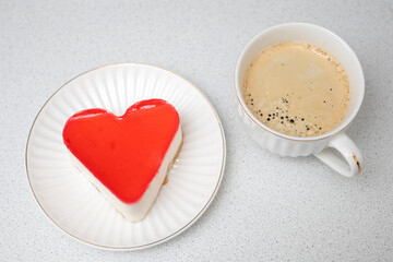 Red heat shaped cake for St. Valentines Day celebration with cup of coffee