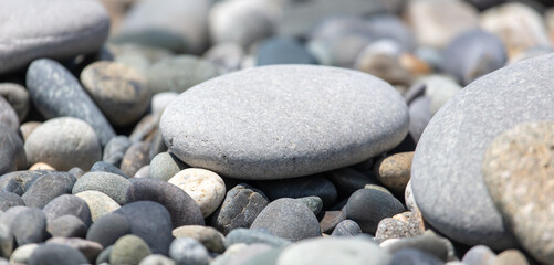 Fototapeta na wymiar Stone pebbles on the beach as a background.
