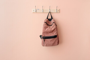 Pink backpack on hook clothes hanger - obrazy, fototapety, plakaty